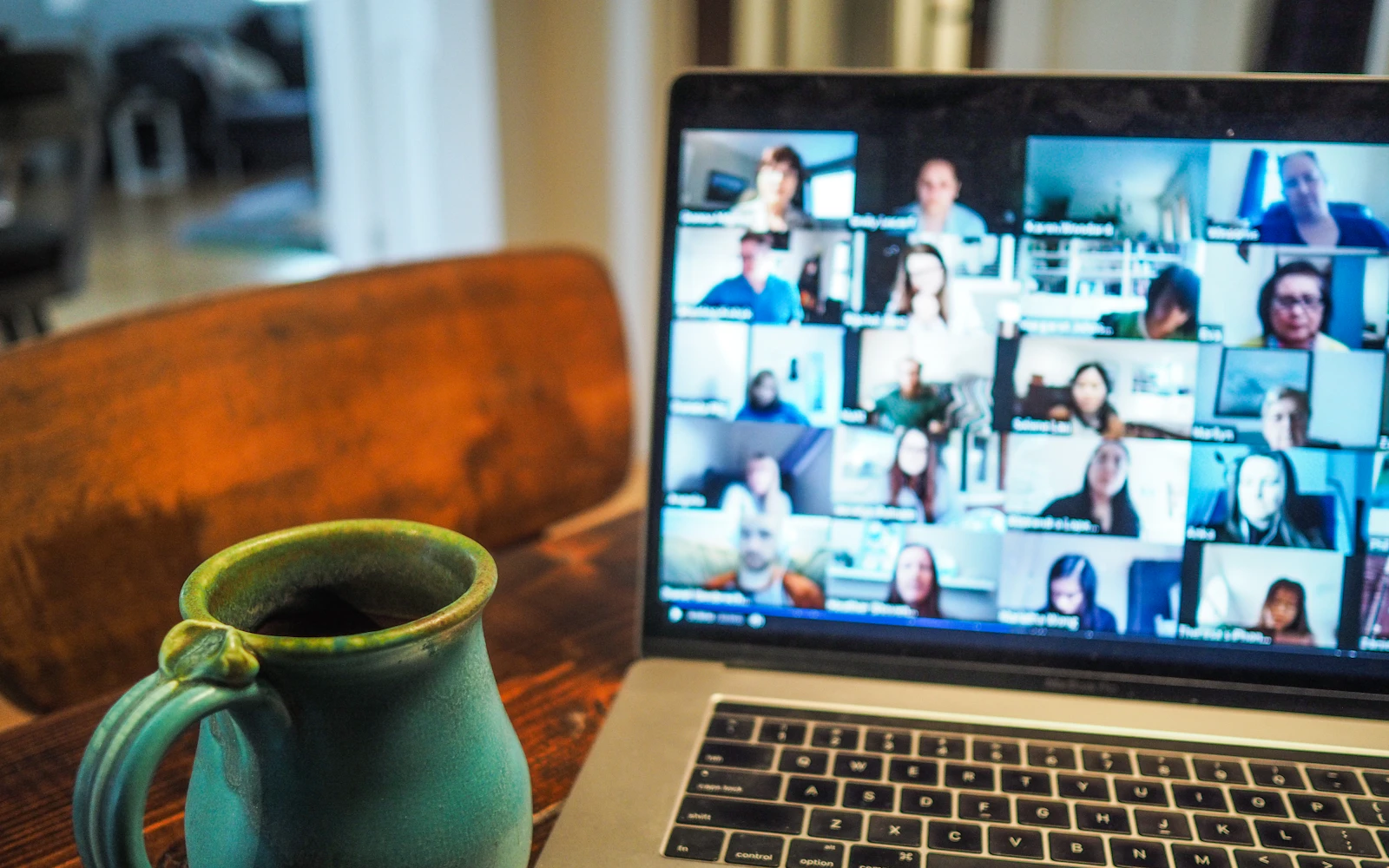 A laptop showing a video call with many participants